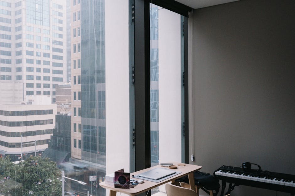 Elegant home office setup overlooking Sydney's urban architecture through large windows.