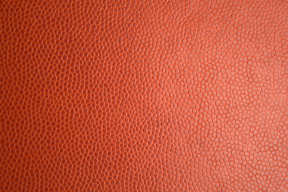 Detailed macro photo of orange leather texture, perfect for backgrounds or materials.