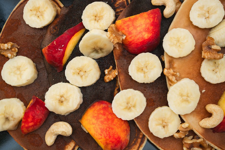 Close-up of pancakes topped with bananas, peaches, and nuts, perfect for a healthy breakfast.