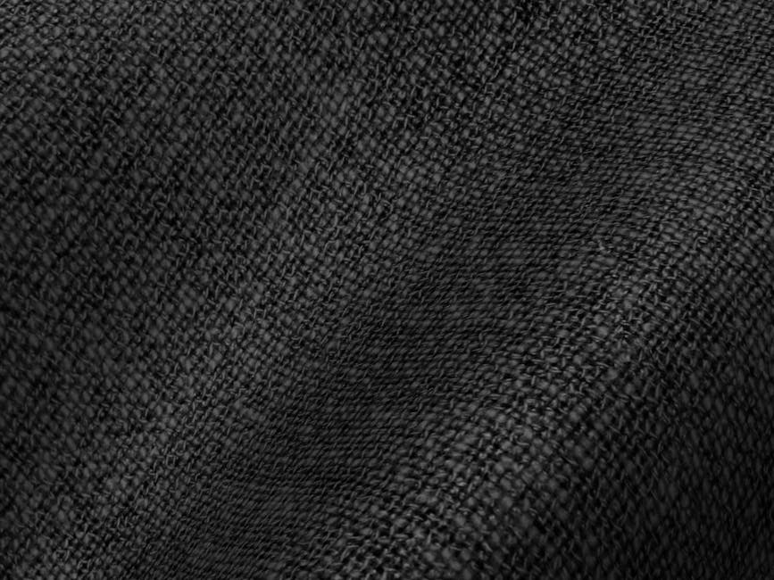 Detailed black fabric texture showing intricate weave and subtle ripples.