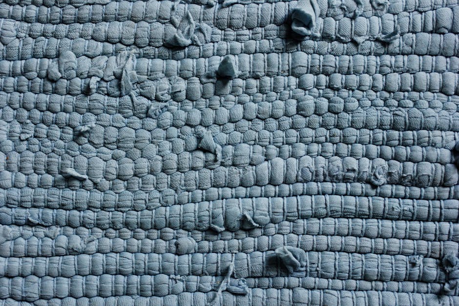 Detailed view of a textured blue fabric showing its intricate woven pattern and rough surface.