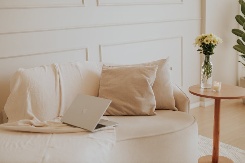 A serene minimalist living space with a laptop and flowers, perfect for remote work.