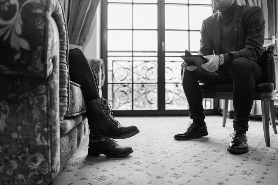 Monochrome image of a therapy session capturing a professional and client in discussion.