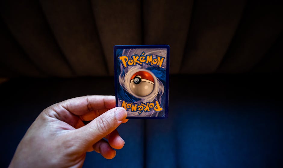 A hand holds a Pokémon trading card with a dark background, emphasizing gaming culture.